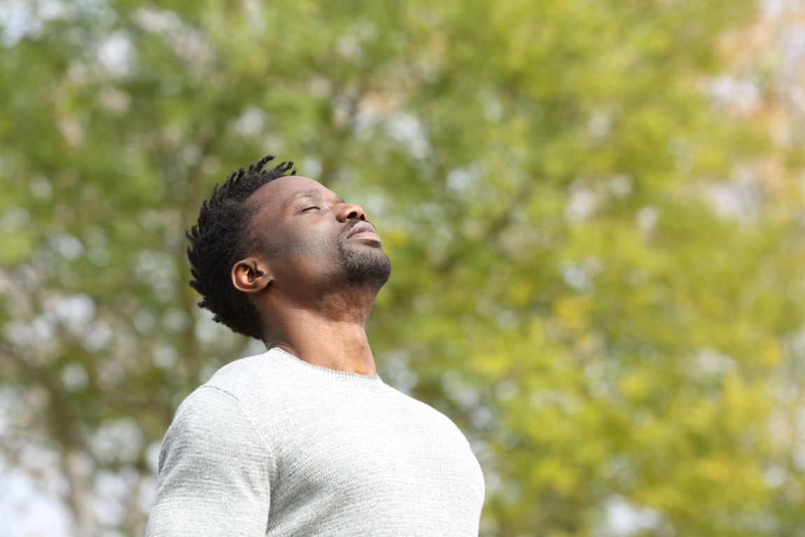 Rhinitis Sufferer Needing Propel Sinus Implant man breathing through nose in front of trees